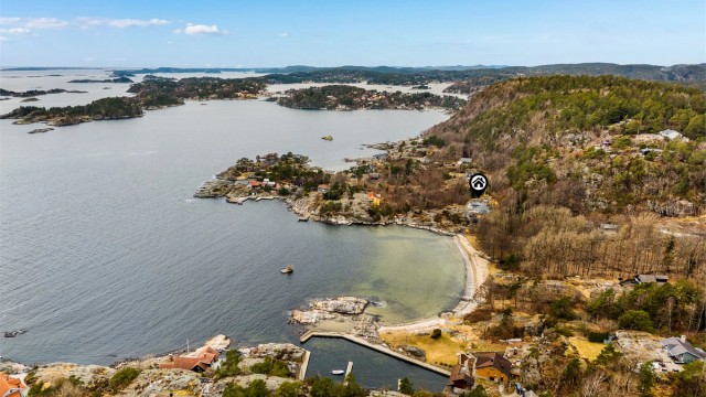 Fritidseiendommen ligger nydelig til med svaberg, strand og brygge rett nedenfor.