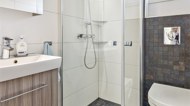 Badet i første etasje er flislagt og har gulvvarme. Rommet er utstyrt med vegghengt toalett og dusjhjørne.
