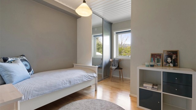 Svalt soverom med skyvedørsgarderobe og god plass til seng og øvrig møblement