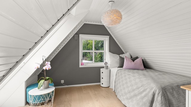 Loftetasjen består av et romslig soverom med skråtak som gir rommet en lun og særpreget karakter.