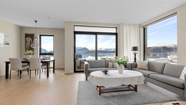 Den åpne stue- og kjøkkenløsningen har store vindusflater som slipper inn rikelig med lys og rammer inn utsikten