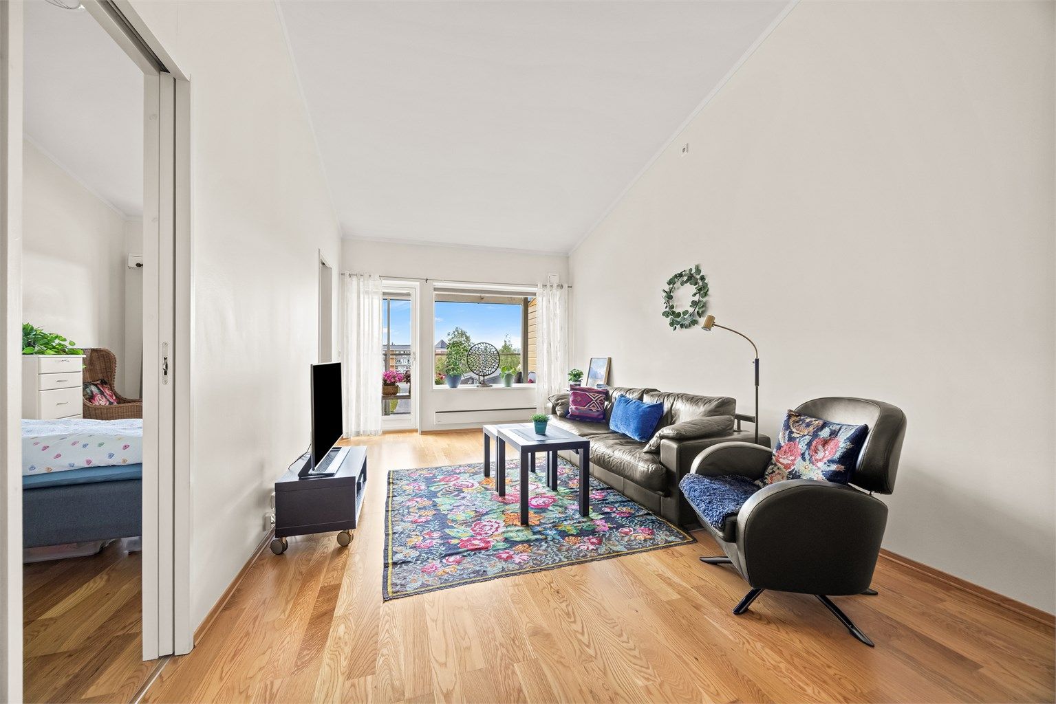 Stuen har god plass til sofagruppe og utgang til den overbygde balkongen.