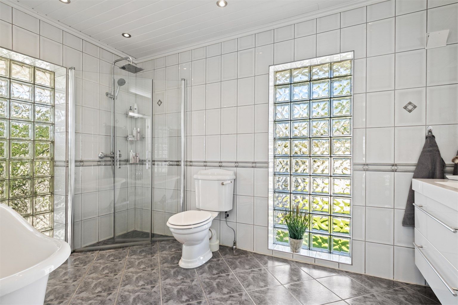 Badet i første etasje er fra 2001 og fremstår ekstra lyst og luftig med store felter i glassbyggerstein på to sider av rommet. 