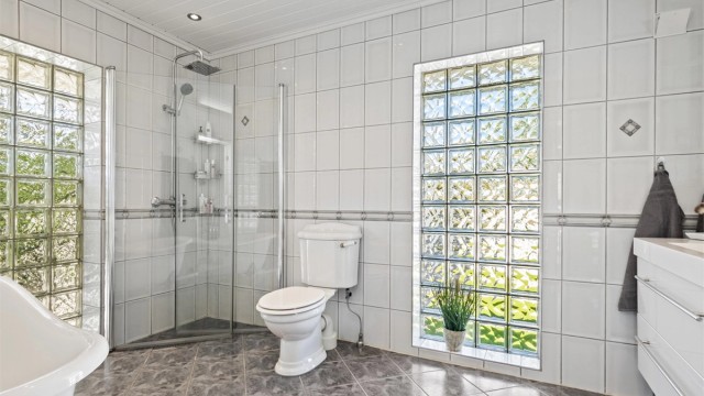 Badet i første etasje er fra 2001 og fremstår ekstra lyst og luftig med store felter i glassbyggerstein på to sider av rommet.