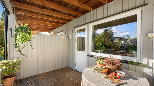Overbygget balkong med skjermet uteplass og god plass til sittegruppe.