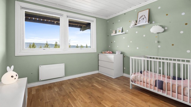 Soverom nr 2 har tre-stavs parkett, malte slette vegger og panel i himling.