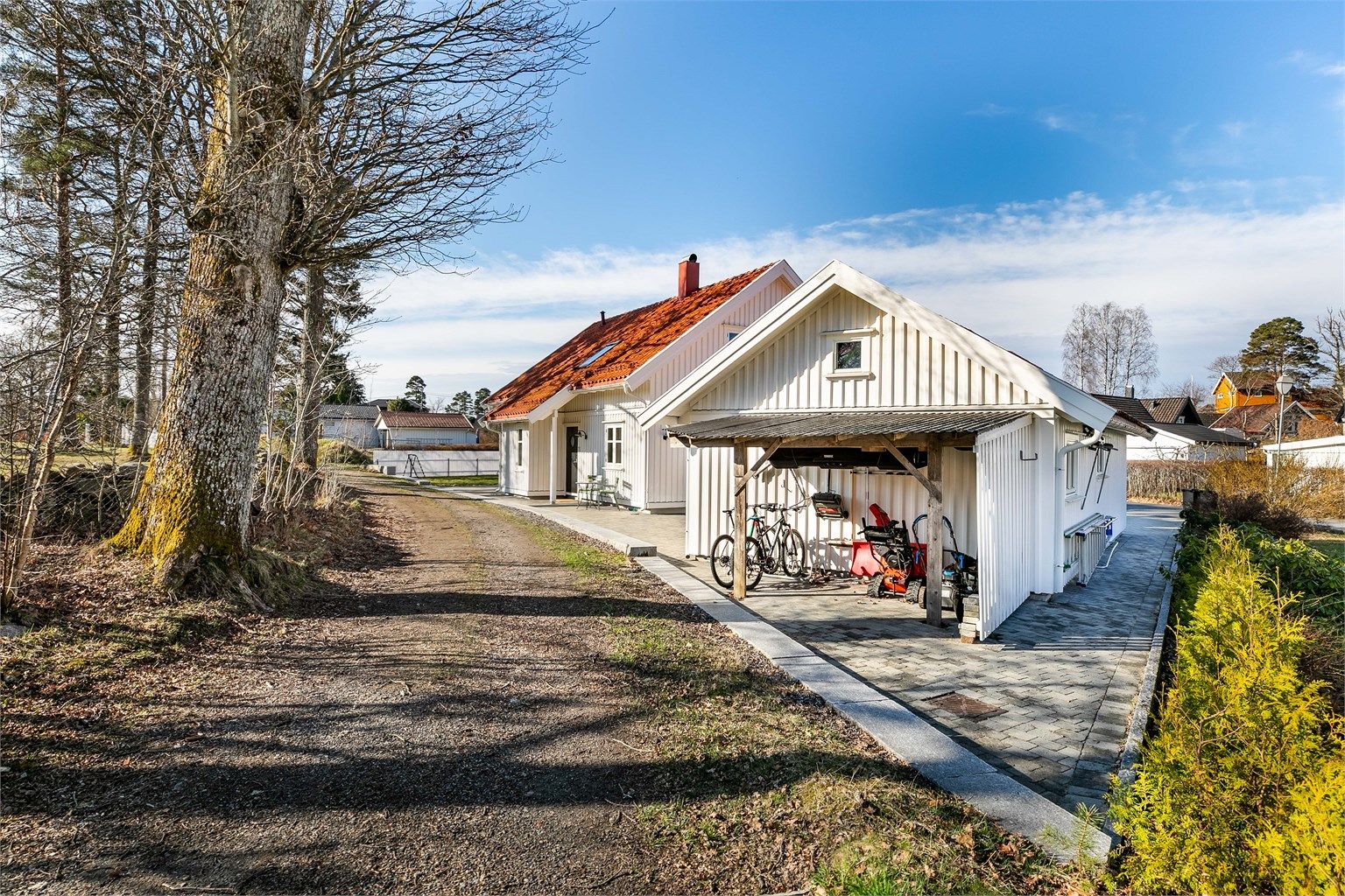 I bakkant av garasjen er det oppført skjul der hageredskaper, sykler eller ved kan oppbevares under tak.
