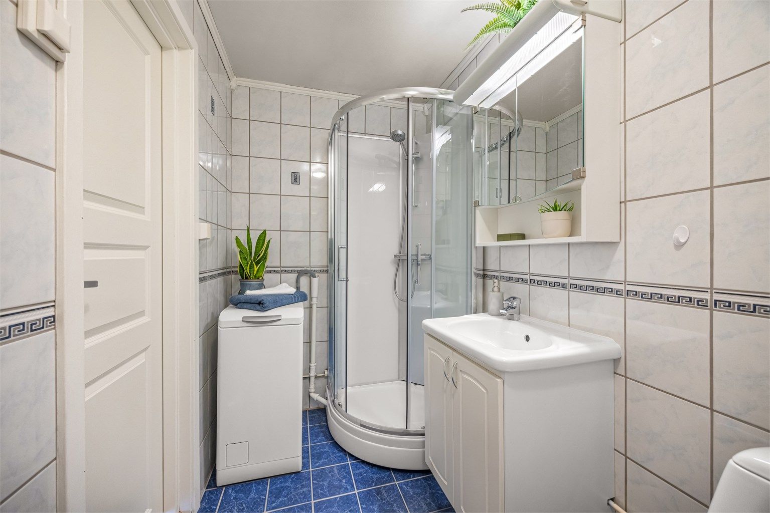 Badet har dusjkabinett og opplegg for vaskemaskin. Vaskemaskin medfølger.