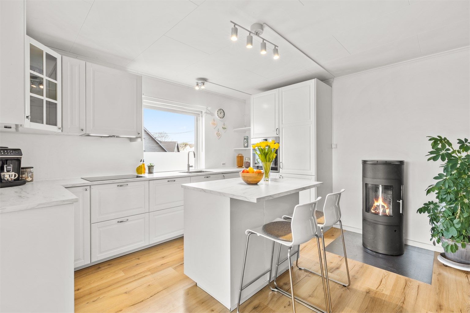 Pent og åpen kjøkkenløsning med peis.