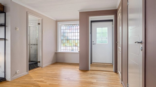 En av boligens to entréer har direkte tilknytning til oppholdsrommene.