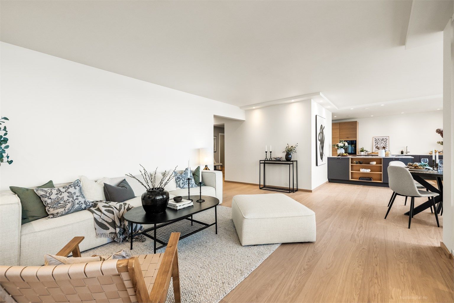 Den åpne løsningen mellom stue og kjøkken skaper en luftig og sosial sone for samvær.