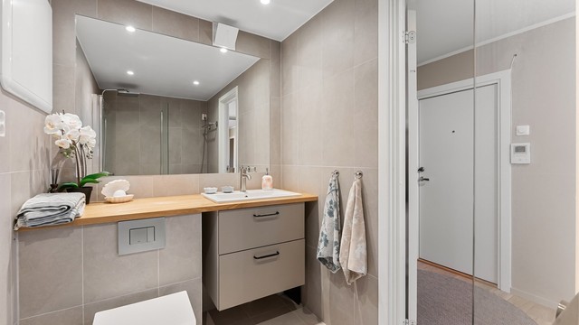 Badet har termostatstyrte varmekabler i gulvet og downlights i himlingen.