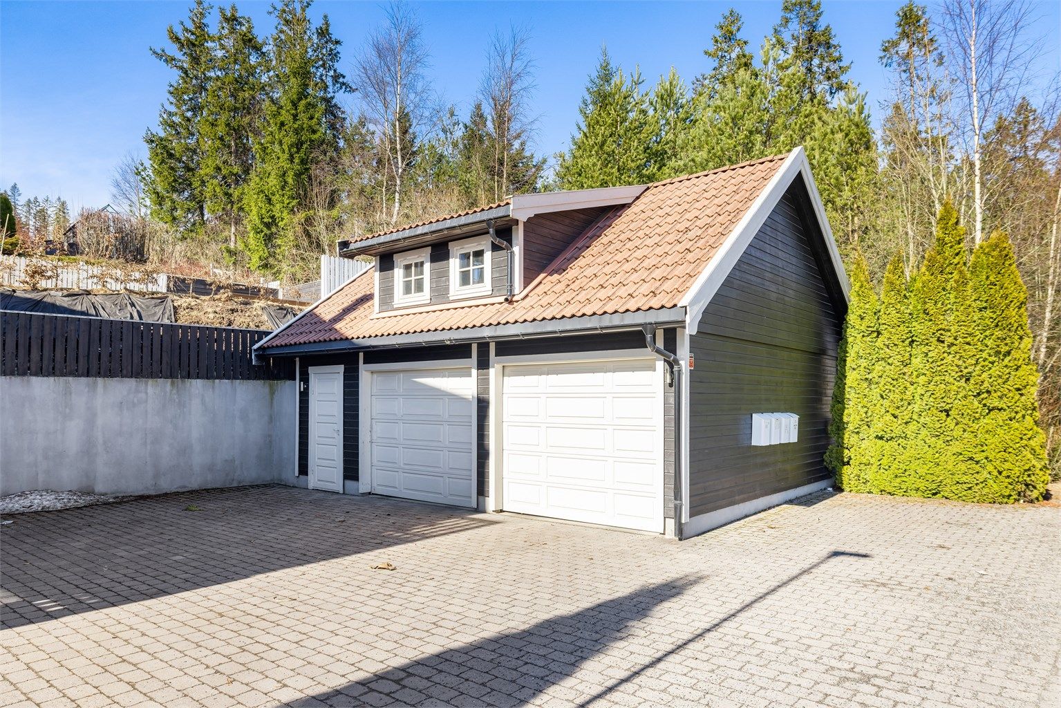 Dobbelgarasje på 46 m² med innlagt strøm og elbillader. En romslig hems med gulvareal på ca. 36 m² gir rikelig med lagringsplass.