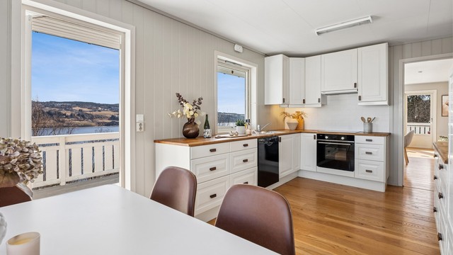 Med plass til en koselig spiseplass og egen utgang til veranda gjør dette kjøkkenet også til et attraktivt oppholdsrom.