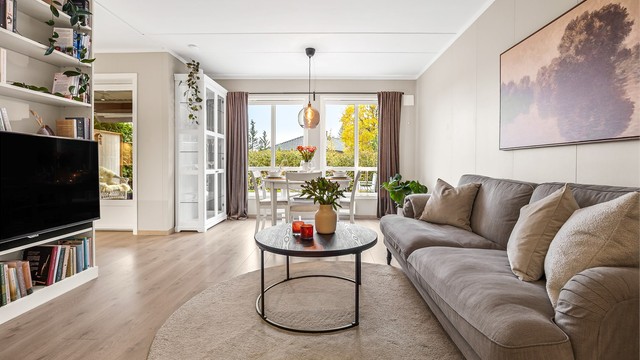 Stue med sofaområde og spiseplass.