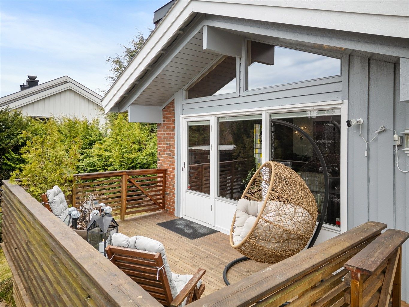 Balkongen er bygget i trekonstruksjoner og har to trapper ned til hagen, som gir en praktisk forbindelse til uteområdet.