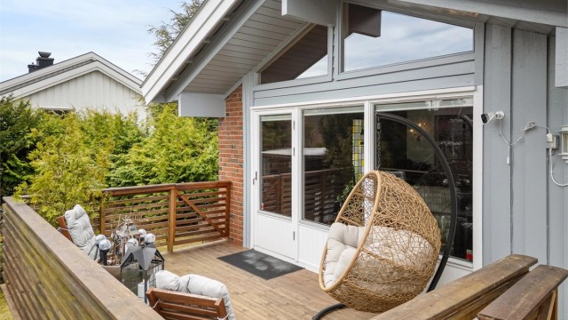 Balkongen er bygget i trekonstruksjoner og har to trapper ned til hagen, som gir en praktisk forbindelse til uteområdet.