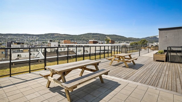 Beboere har tilgang til en romslig felles takterrasse med sittebenker - Sommerbilde fra tidligere annonse.