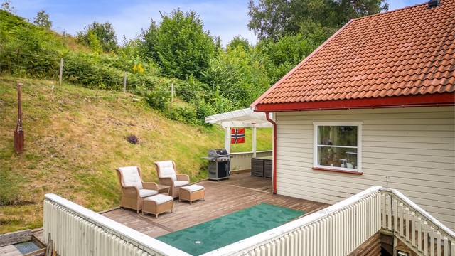 En del av terrassen er overbygget (ikke byggemeldt), og gir ly for utemøblene.