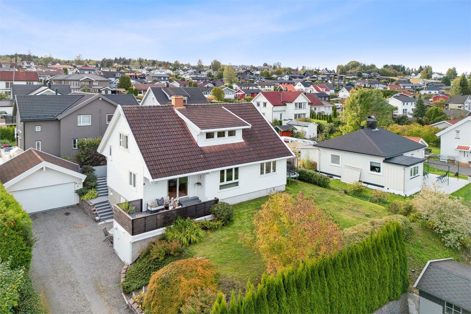 Eiendommen har dobbelgarasje, pent opparbeidet hage og flere uteplasser. 