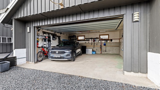 Romslig dobbelgarasje med bred port med automatisk portåpner. I garasjen er det også etablert el-bil lader. Loftsrom med adkomst fra baksiden med fine lagringsmuligheter.