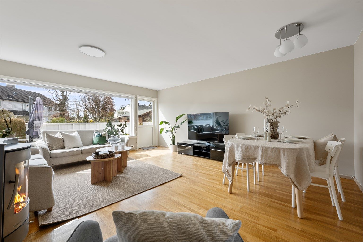 Stuen oppleves som lyst og luftig med store vindu, parkett på gulv og malte veggflater. 