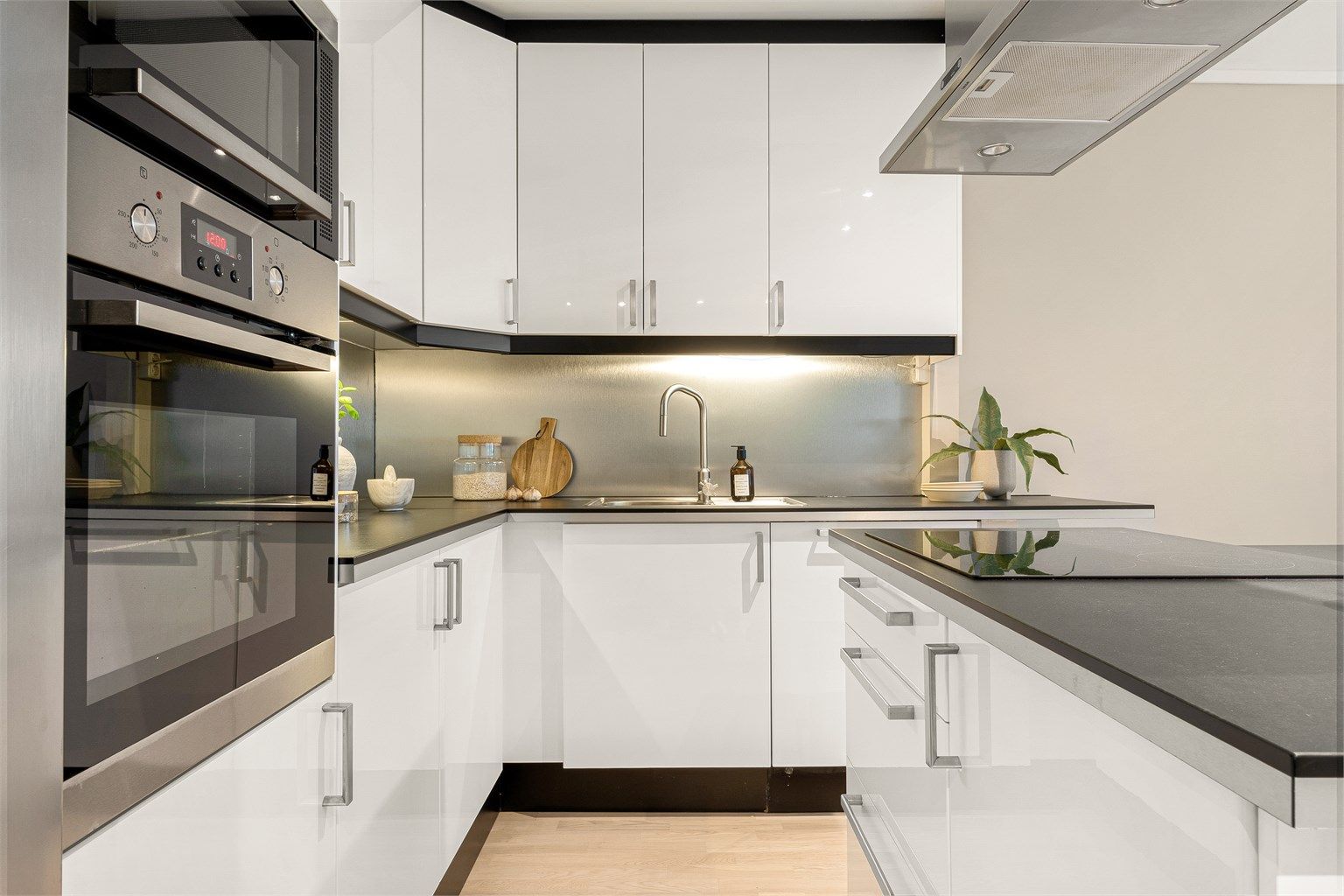 Kjøkkenet har integrerte hvitvarer som oppvaskmaskin, steke -og mikrobølgeovn samt platetopp på kjøkkenøyen. 