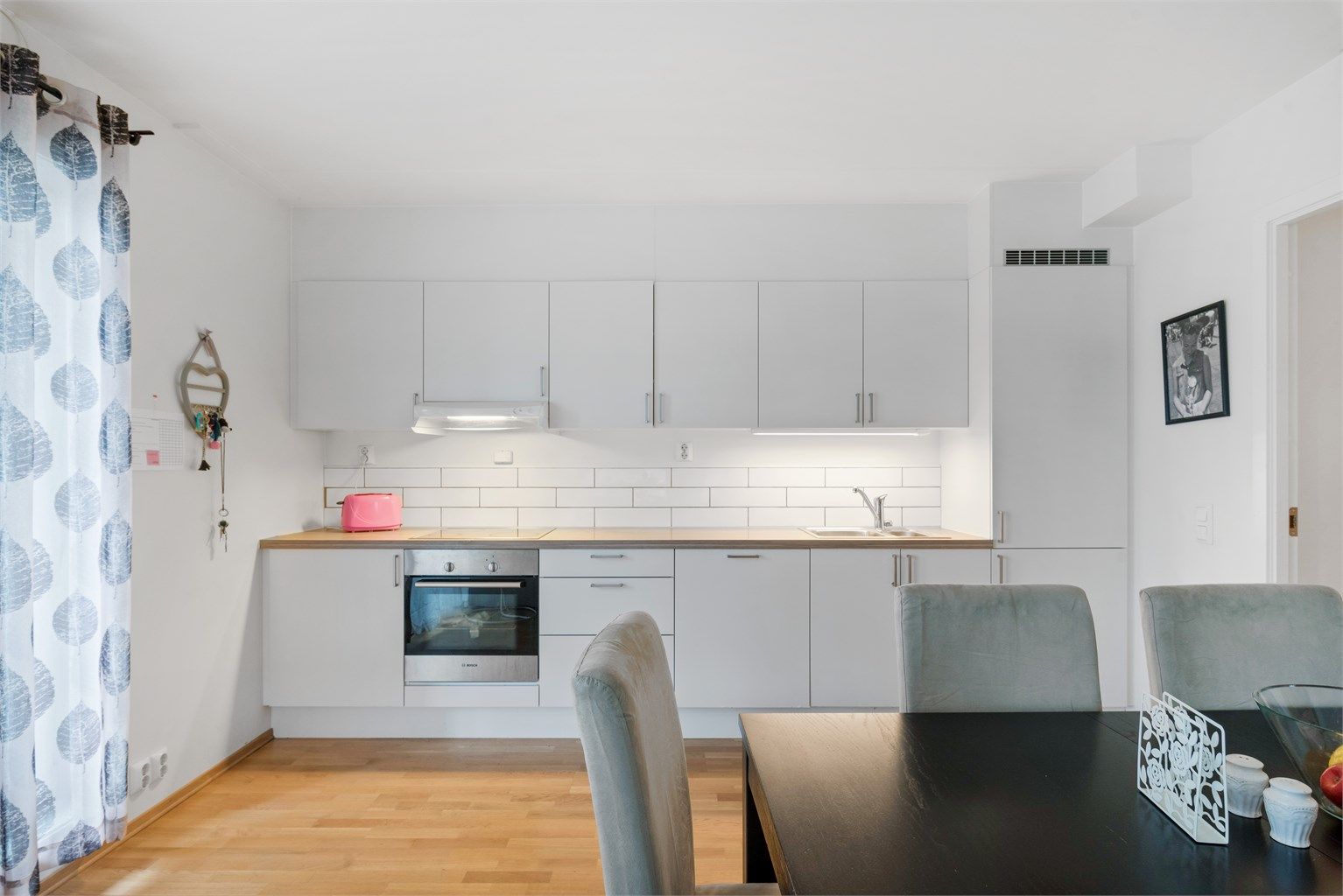 Pent og moderne kjøkken med integrerte hvitevarer.