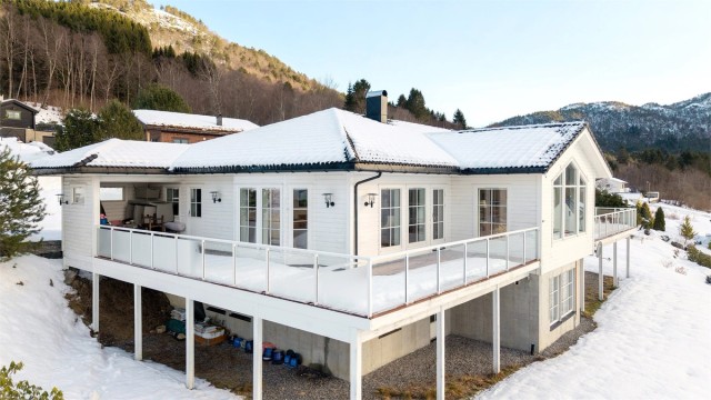 Store vindusflater og en omkransende terrasse er designet for å maksimere utsikten mot Sunnmørsalpene.