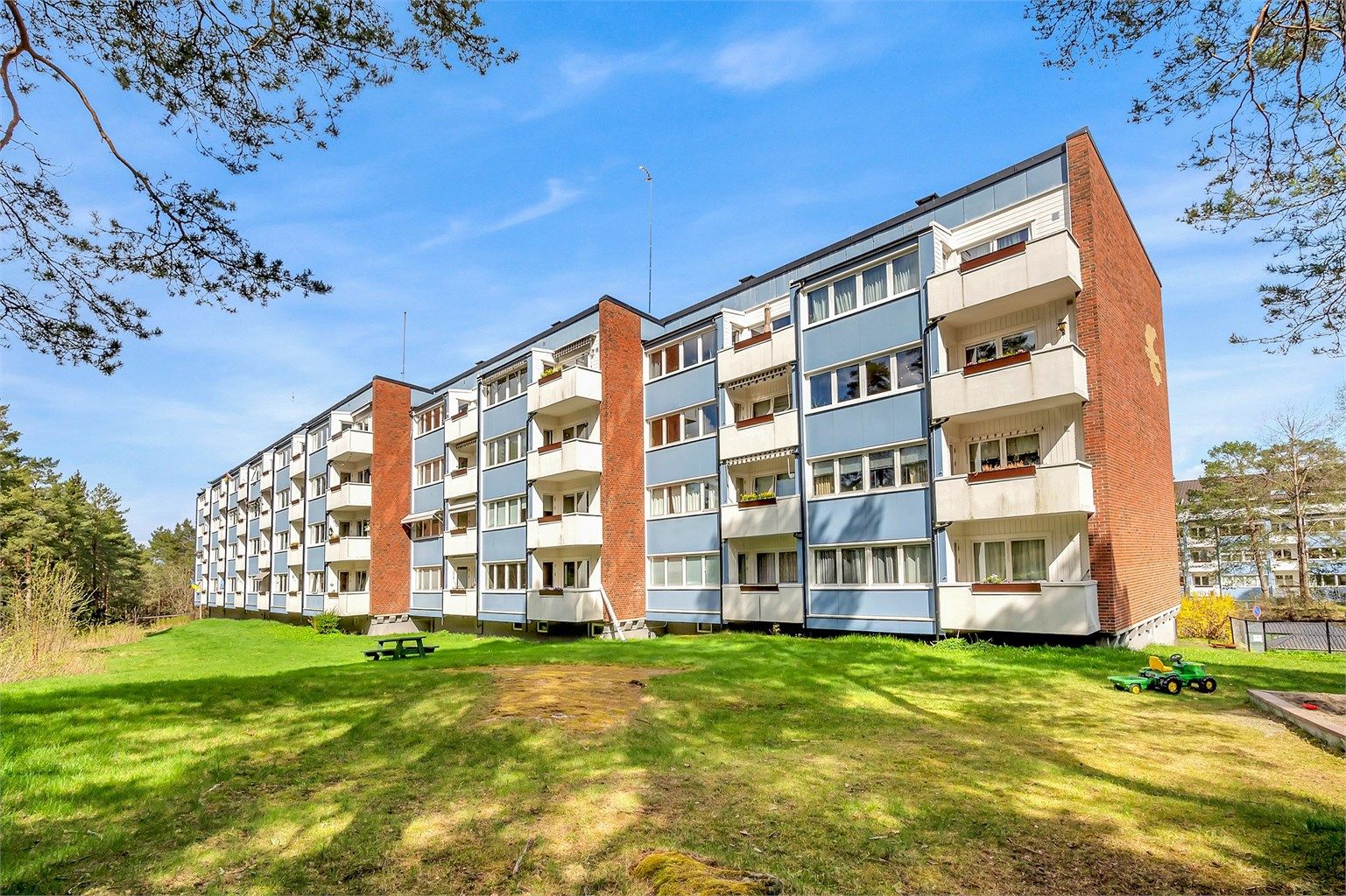 Fasade - balkongside.
Bygningen fra 1959 har fasader kledd med teglstein og fasadeplater.