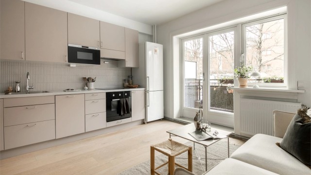 Praktisk kjøkken med glatte stilrene farger og gode materialer. Godt med skap- og benkeplass.