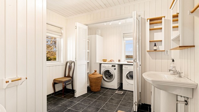 Badet i første etasje fungerer også som vaskerom, med flislagt gulv, gulvvarme. Opplegg for vaskemaskin og tørketrommel finnes i rommets "vaskeromsdel", praktisk oppdelt med egen skillevegg. Her er det også montert benkeplate.