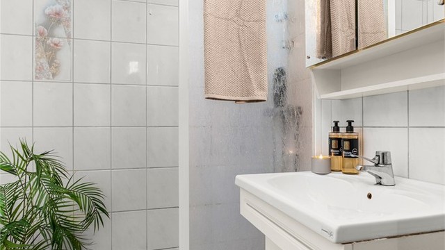 Badet måler 2,5 kvm og har flislagte flater, dusjnisje og servantskap. Det må påregnes noe oppussing.