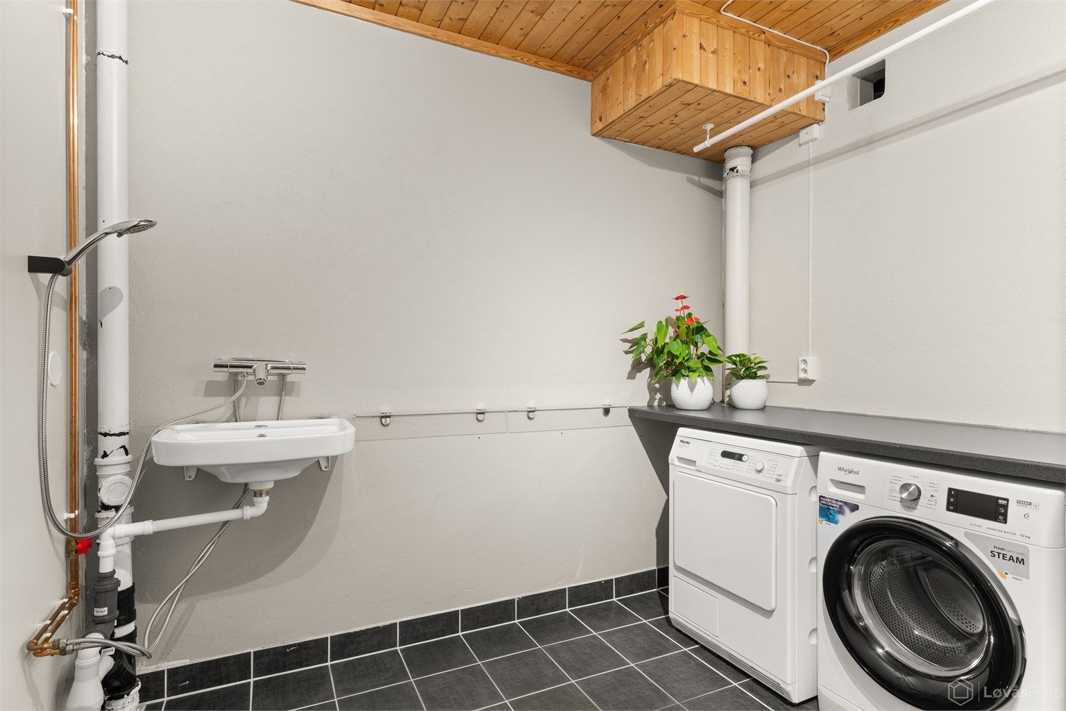 Eget praktisk vaskerom med gulvfliser med gulvvarme