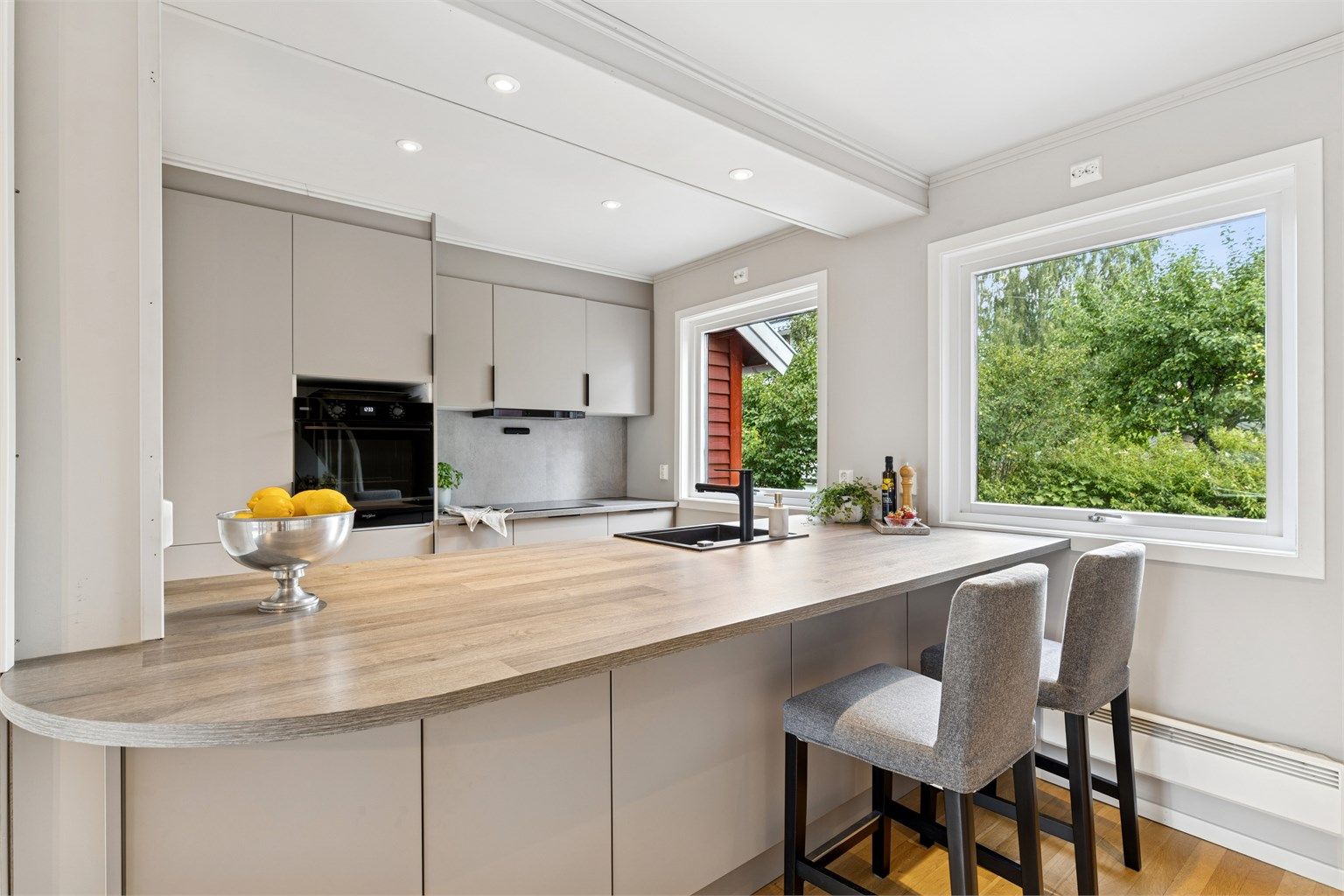 Moderne og stilren HTH kjøkkeninnredning fra 2024 med glatte fronter i tidsriktig farge. Kjøkkenet ligger i åpen og sosial løsning mot stuen