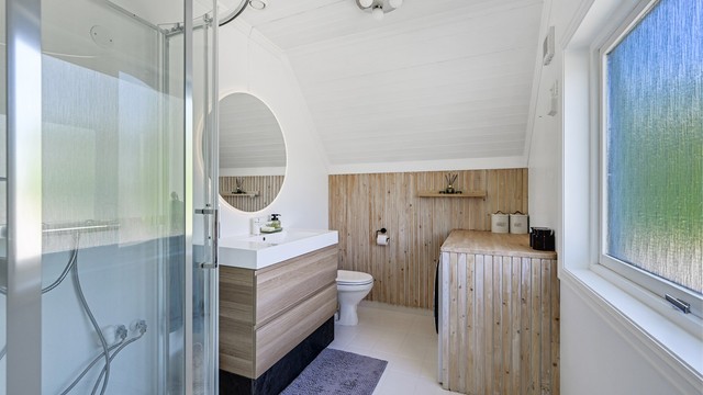 Badet ligger i tilknytning til soverommet og fremstår pent oppgradert med flislagt gulv med varmekabler, samt malt panel på vegger og i tak.