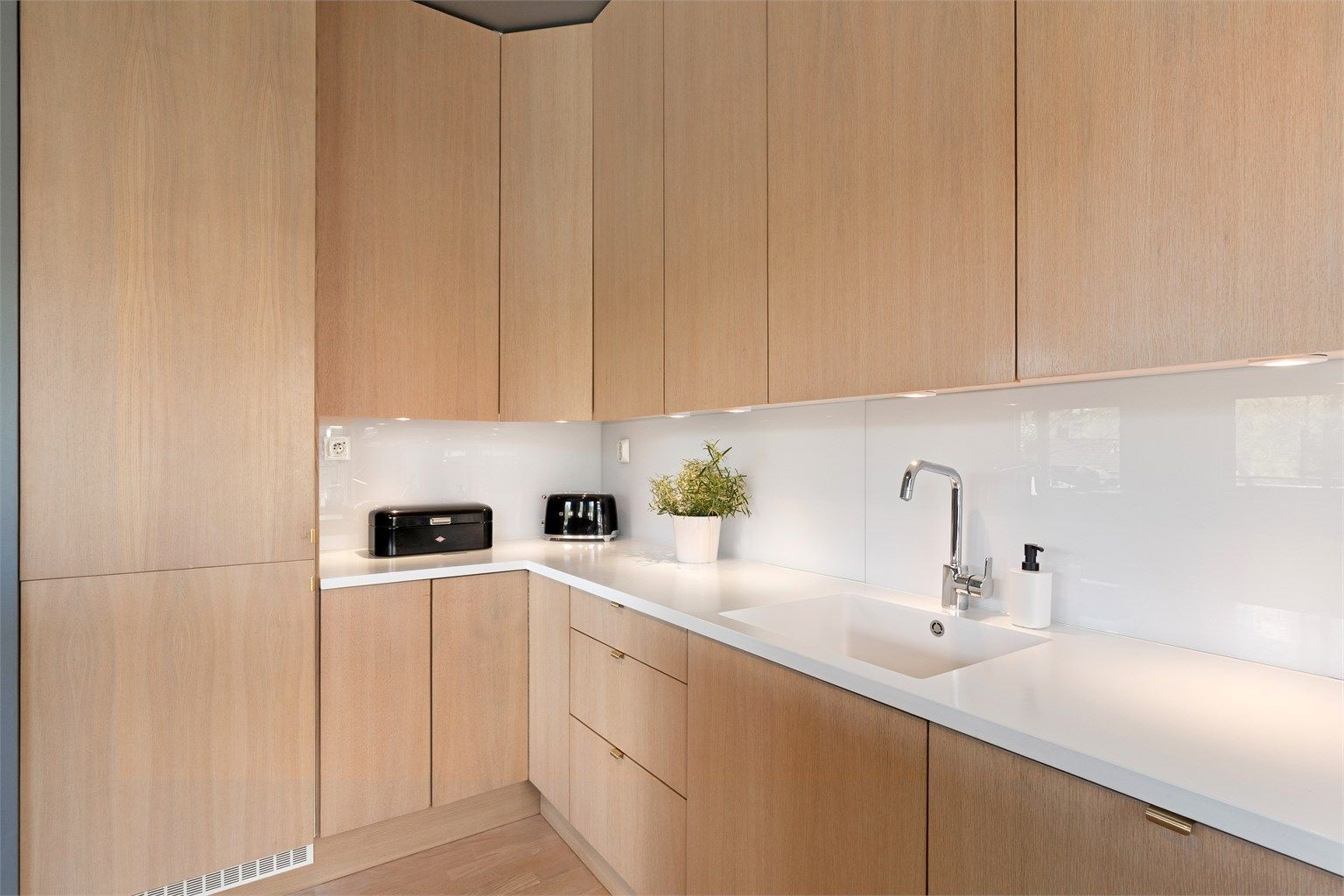 Corian benkeplate med glassplate mellom benk og overskap