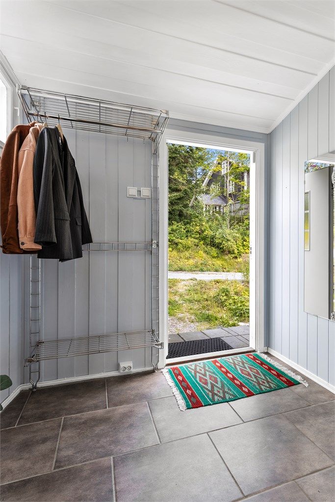 Praktisk entré med flislagt gulv og god plass til oppbevaring av klær og sko.