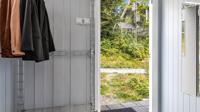 Praktisk entré med flislagt gulv og god plass til oppbevaring av klær og sko.