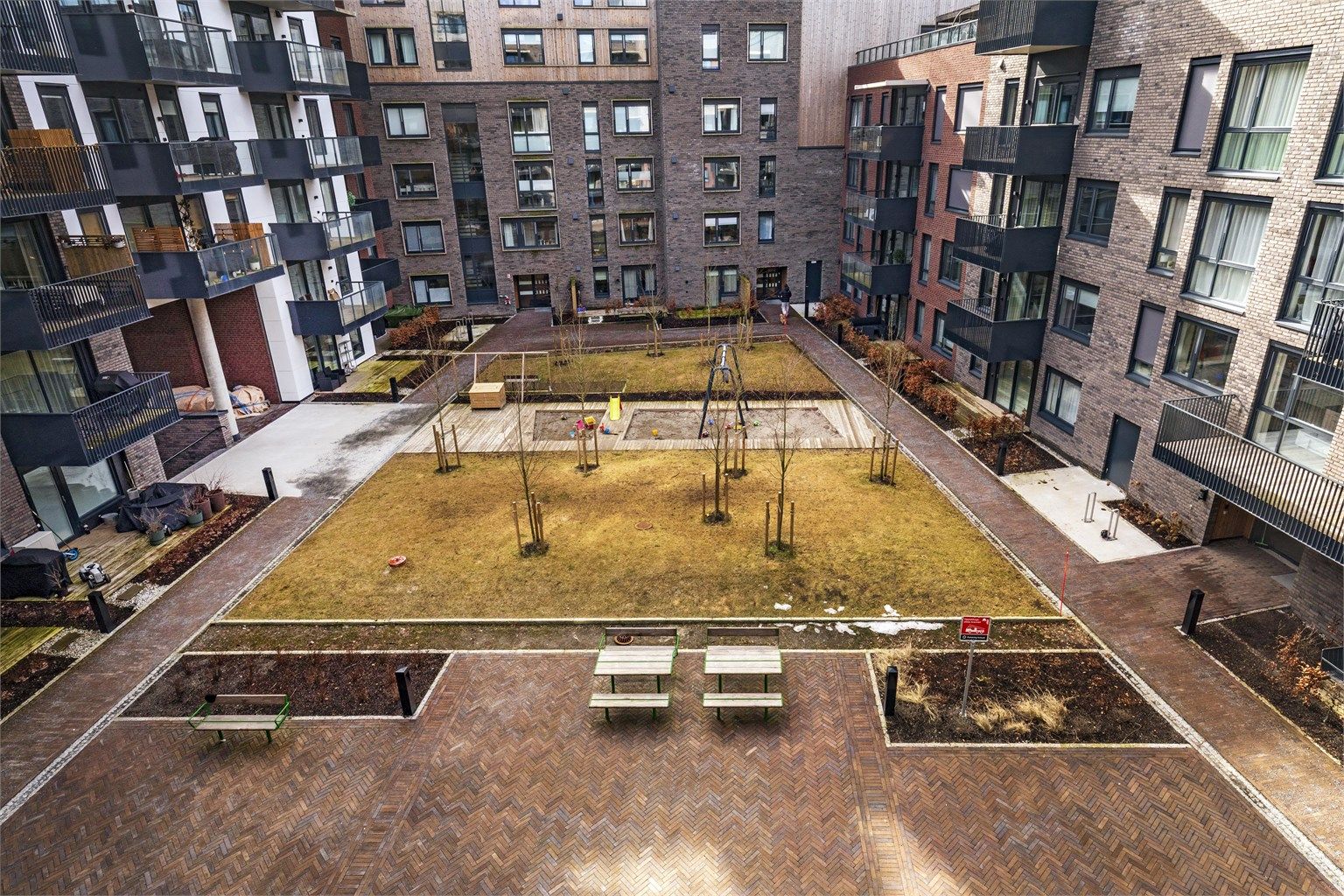 Hyggelig bakgård med sittegrupper, gressplen og lekeplass for de yngste beboerne i borettslaget