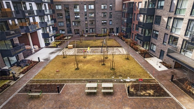 Hyggelig bakgård med sittegrupper, gressplen og lekeplass for de yngste beboerne i borettslaget