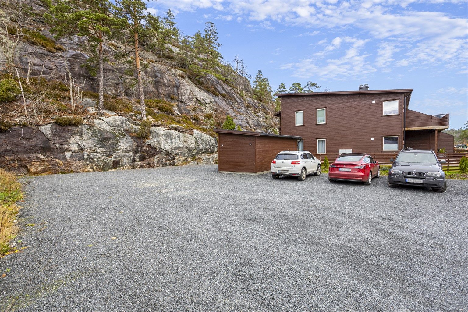 Det er rikelig med parkering på felles, gruset område