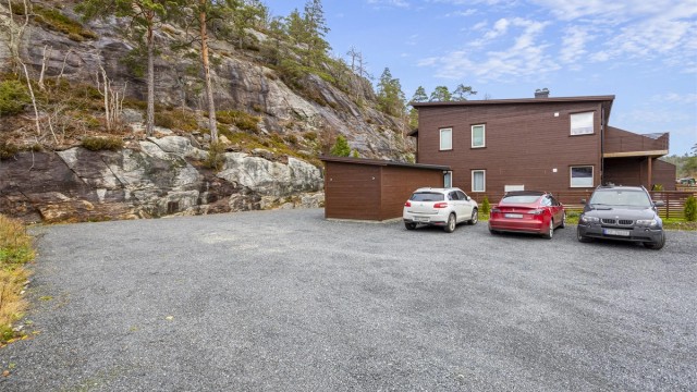 Det er rikelig med parkering på felles, gruset område