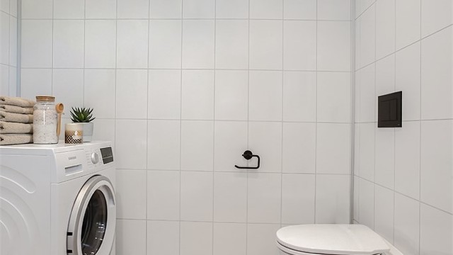 Badet har også opplegg for vaskemaskin, noe som gir en praktisk vaskeromsløsning.