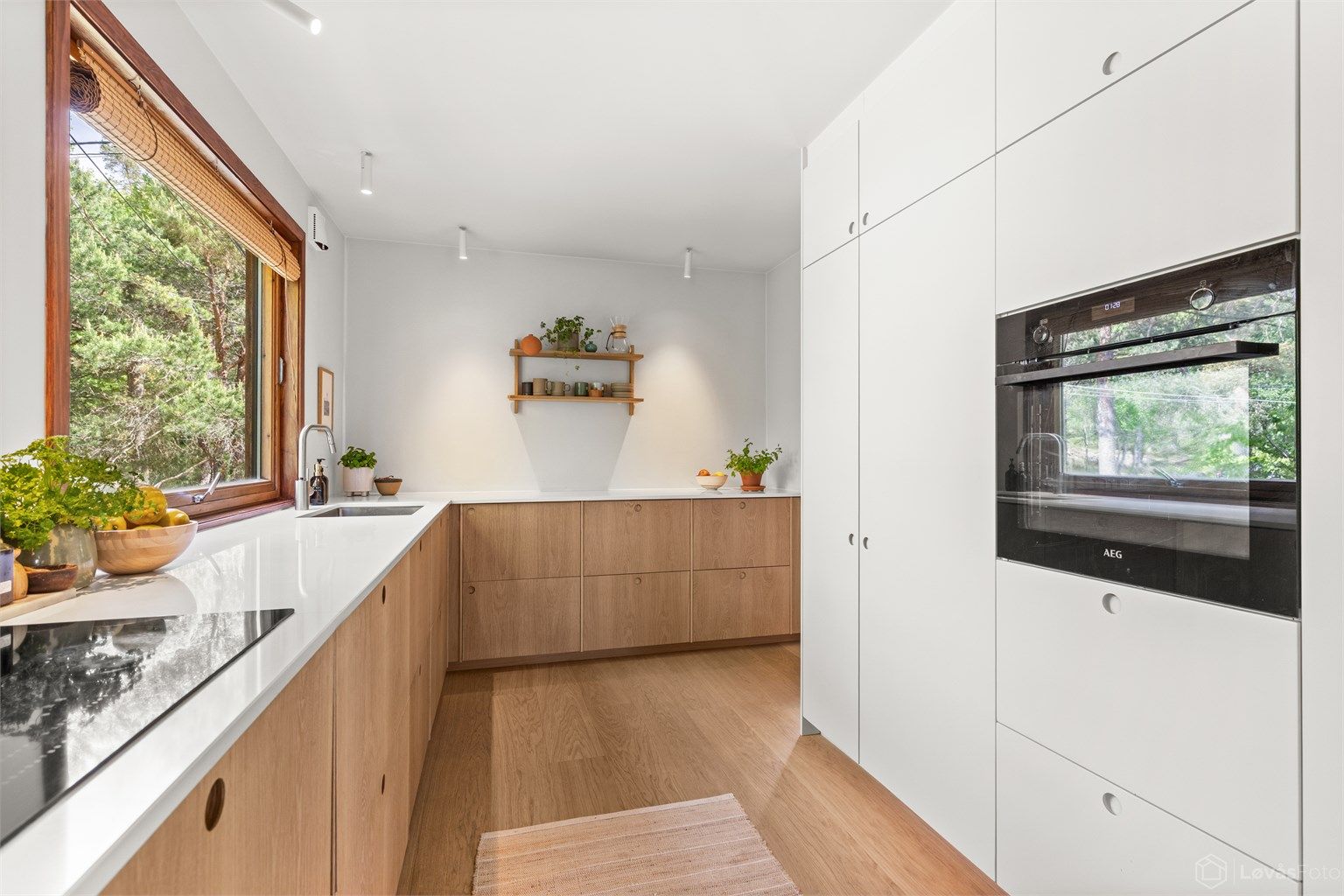 Kjøkkenet er nytt fra 2025 og ligger i åpen løsning mot stuen/spisestuen, noe som gir en sosial og funksjonell planløsning. Store vinduer sørger for godt med lys. Foto: John Løvås