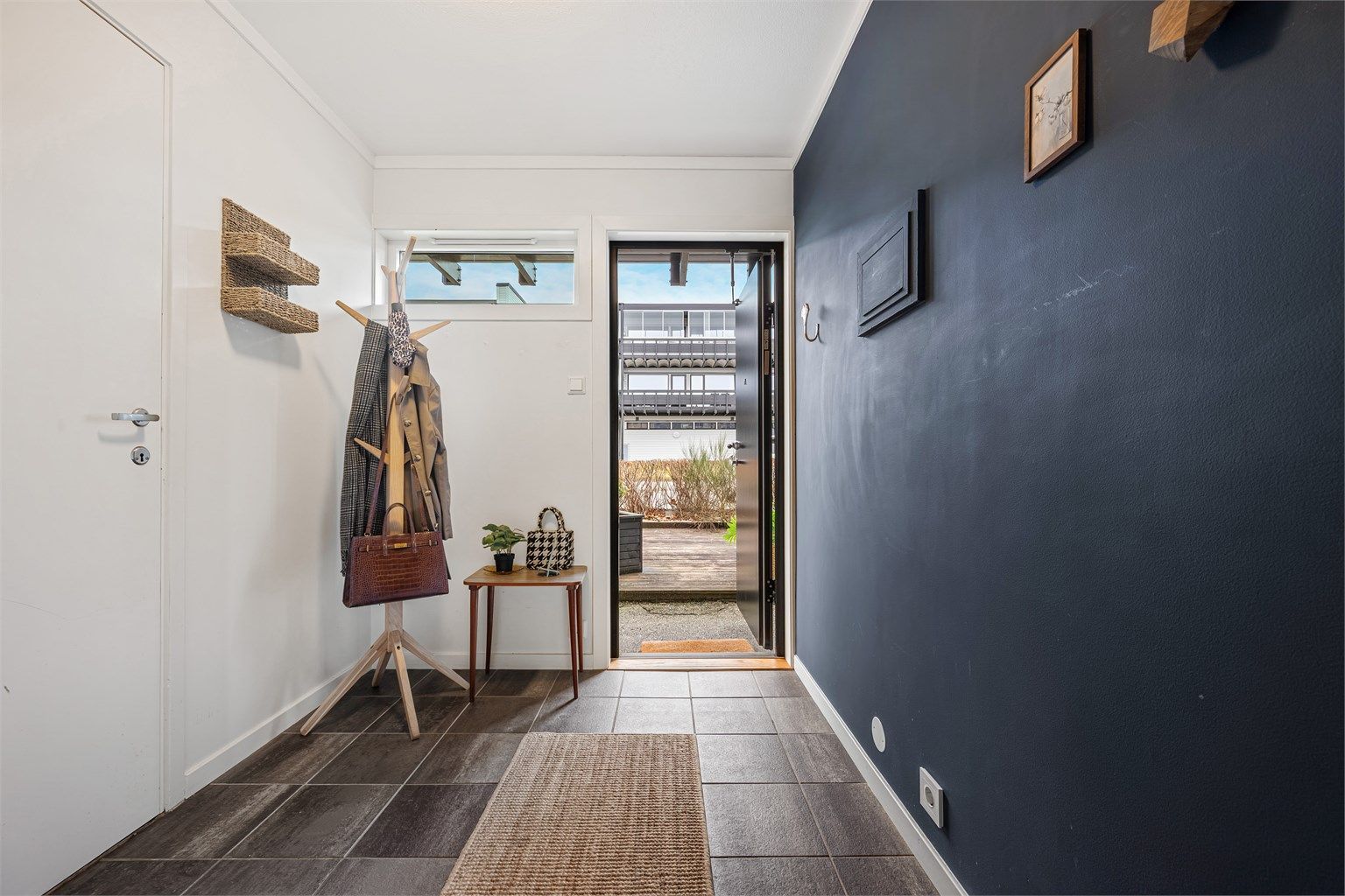 Entré med belegg på gulv, malte vegger og plass til å henge av yttertøy. 
