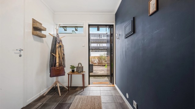 Entré med belegg på gulv, malte vegger og plass til å henge av yttertøy.