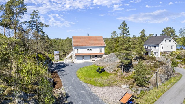 Eiendommen ligger tilbaketrukket på en stor, svakt skrånende tomt med gode solforhold.