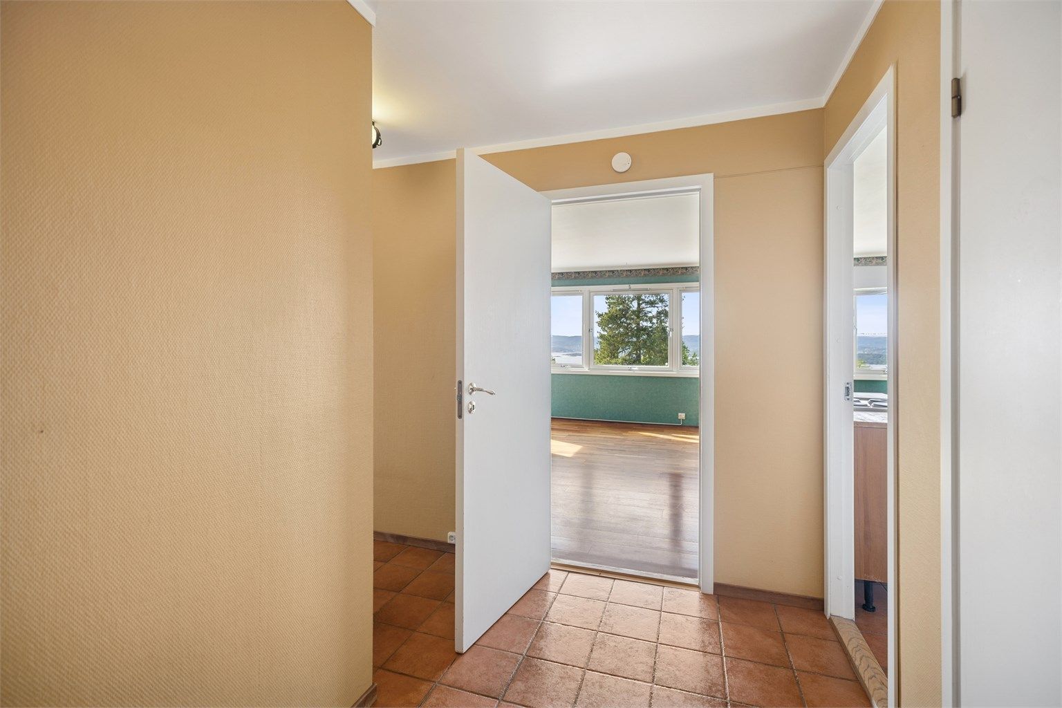 Romslig entré med fliser på gulv og god plass til yttertøy og sko