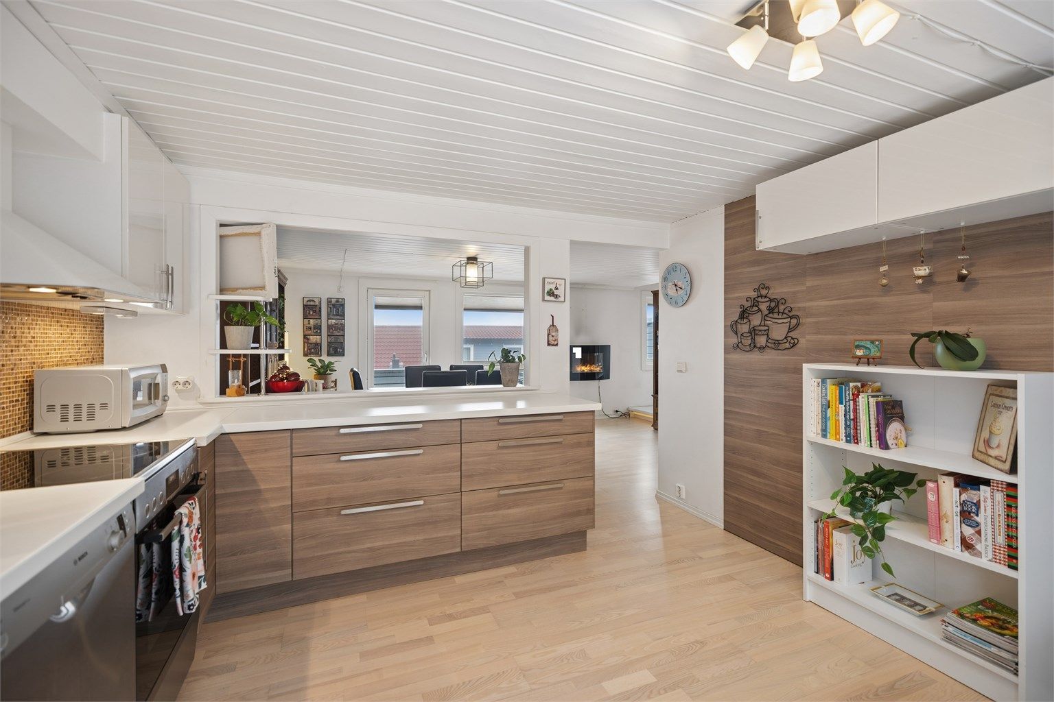 Kjøkkenet er pent og funksjonelt, og den delvis åpne, sosiale løsningen mot spisestuen skaper en naturlig og innbydende sone for både hverdagsmåltider og gjester.